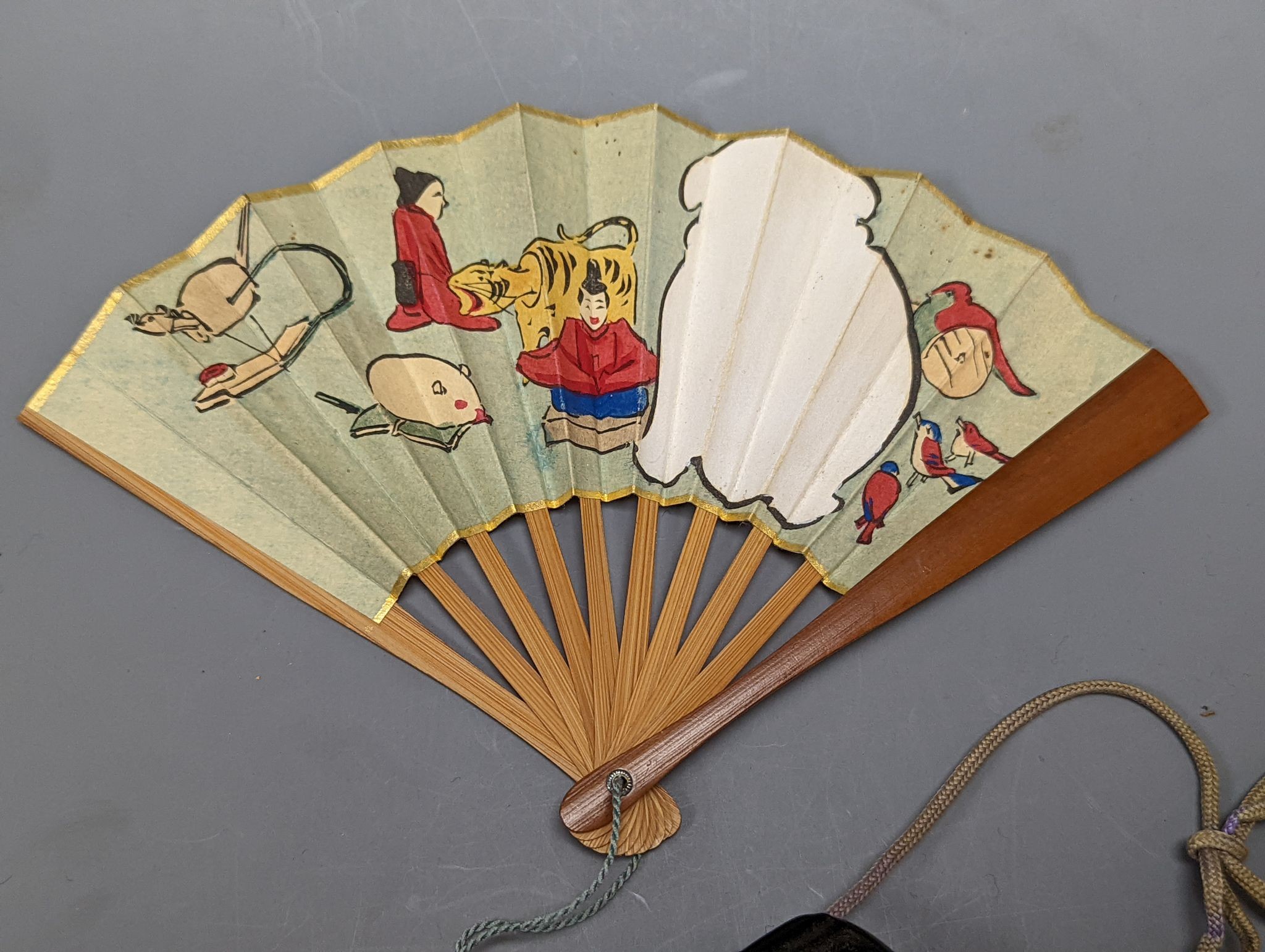 A 19th century Japanese lacquer three-case inro and a small Japanese woodblock printed fan with bamboo guards, 12cm